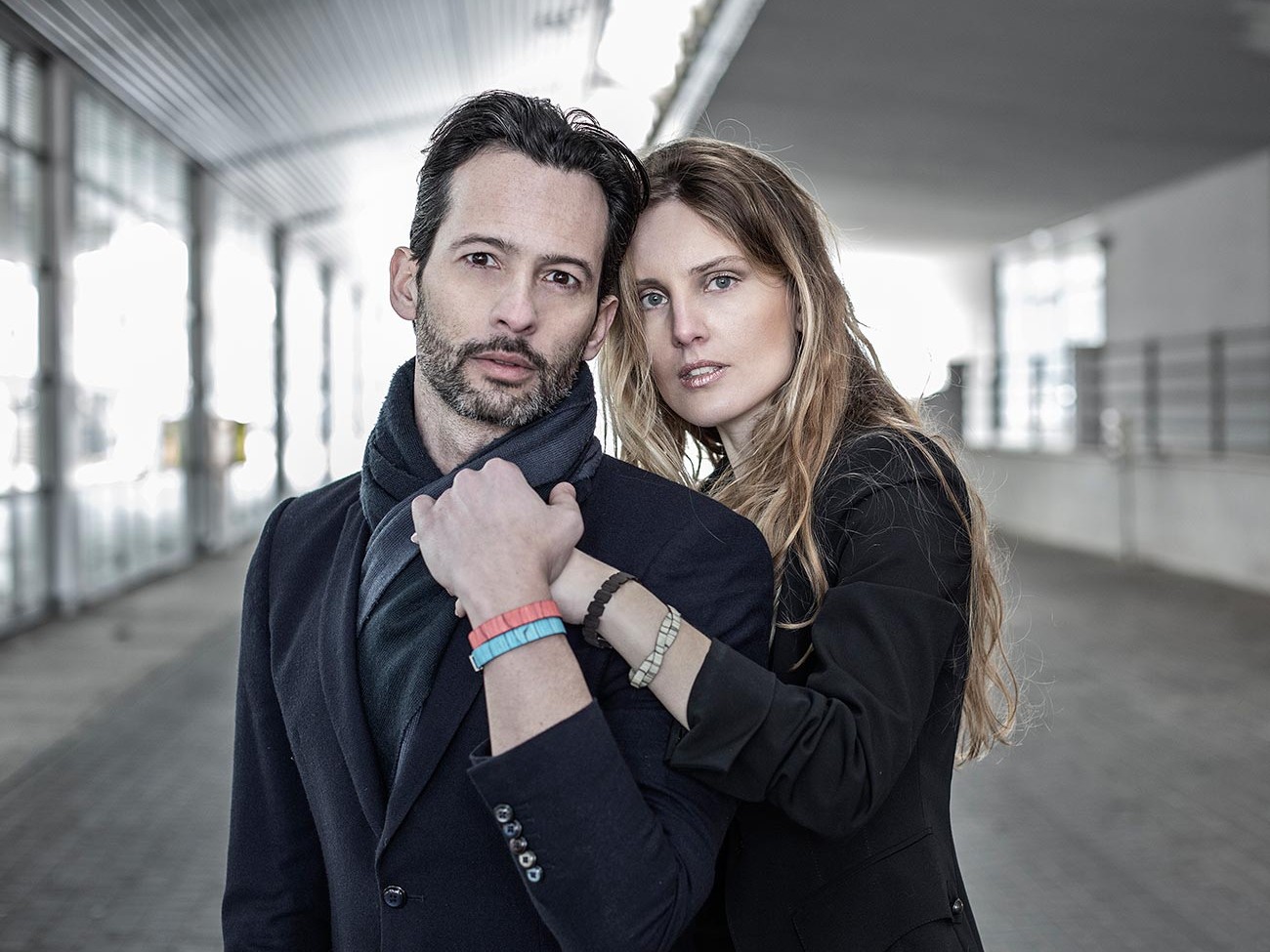 Una donna abbraccia un uomo da dietro indossando i bracciali in legno Paul Cortese