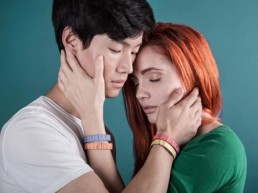 un uomo e una donna si abbracciano indossando i bracciali in legno colorati Pop Wood Paul Cortese